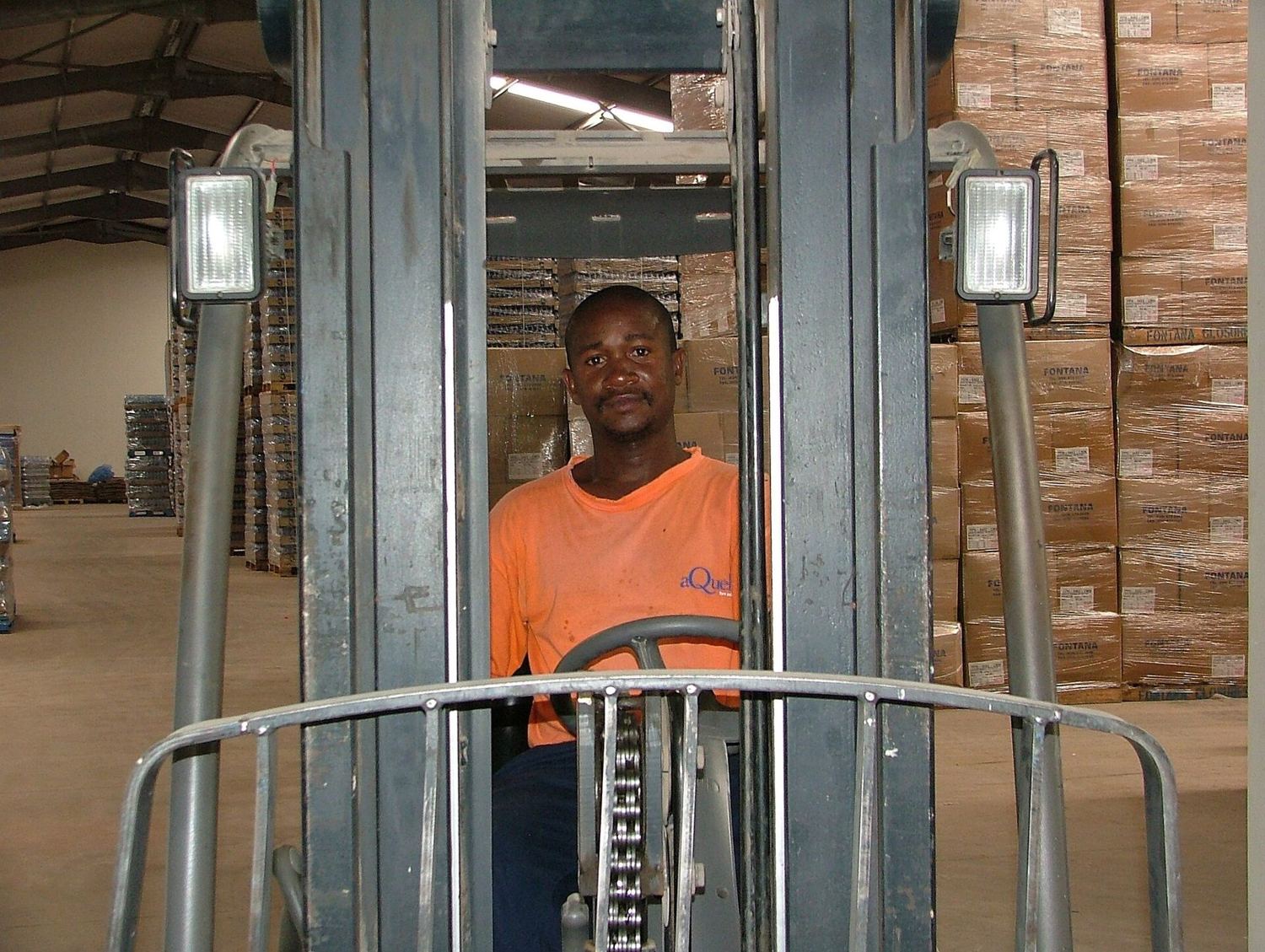 A worker driving a reach truck